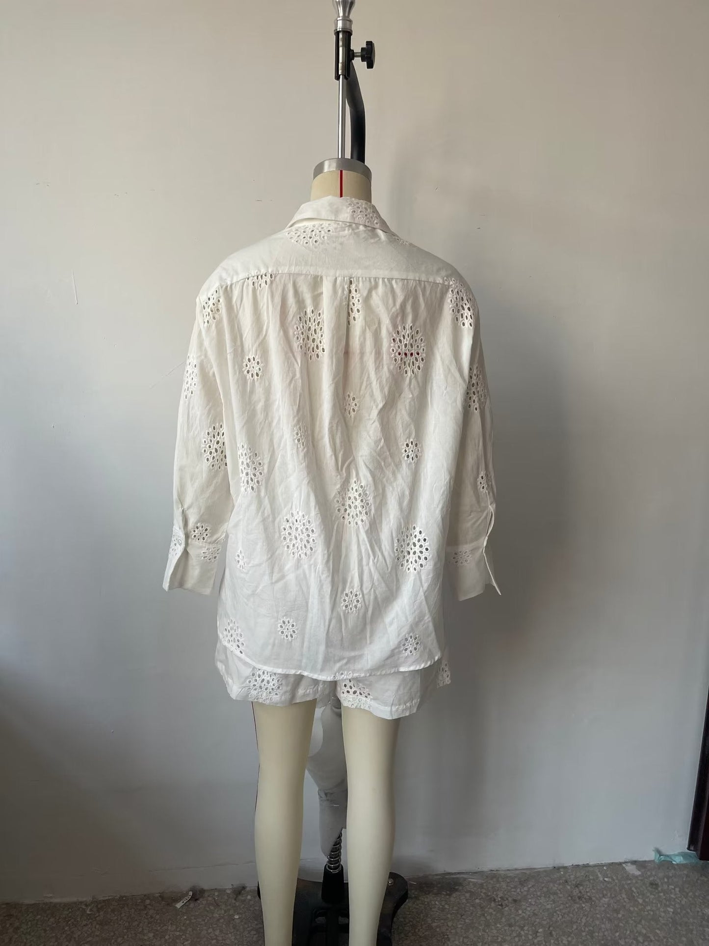 Traje informal blanco con escote en V, camisa bordada de media manga con aberturas y cintura alta, pantalones cortos informales con aberturas y aberturas.