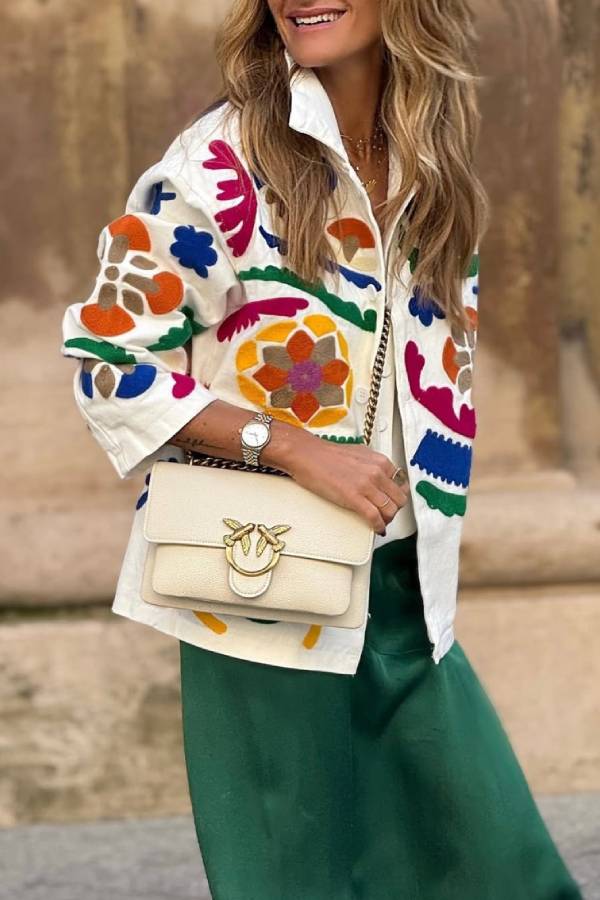 Sobrecamisa vaquera blanca bordada con colores vivos y bolsillos.