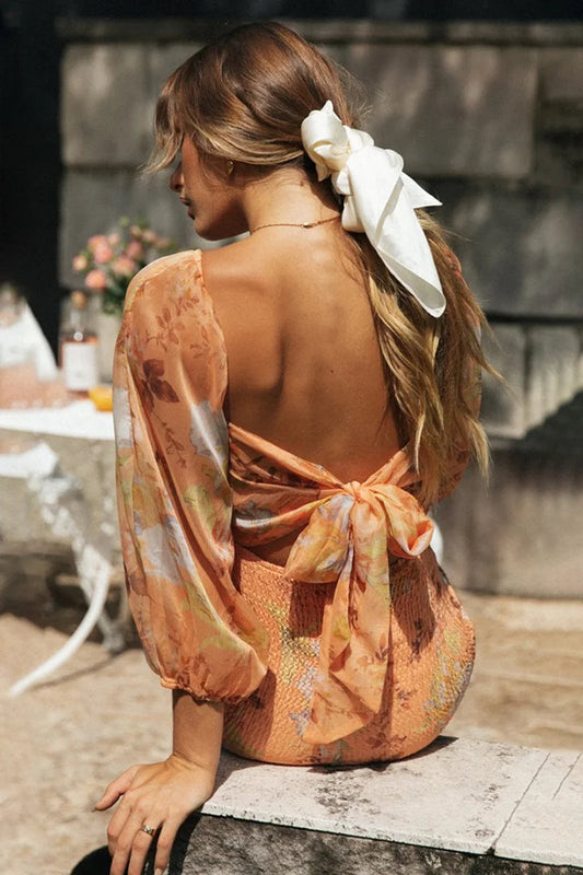 Vestido mini con encaje, espalda descubierta y mangas farol con flores