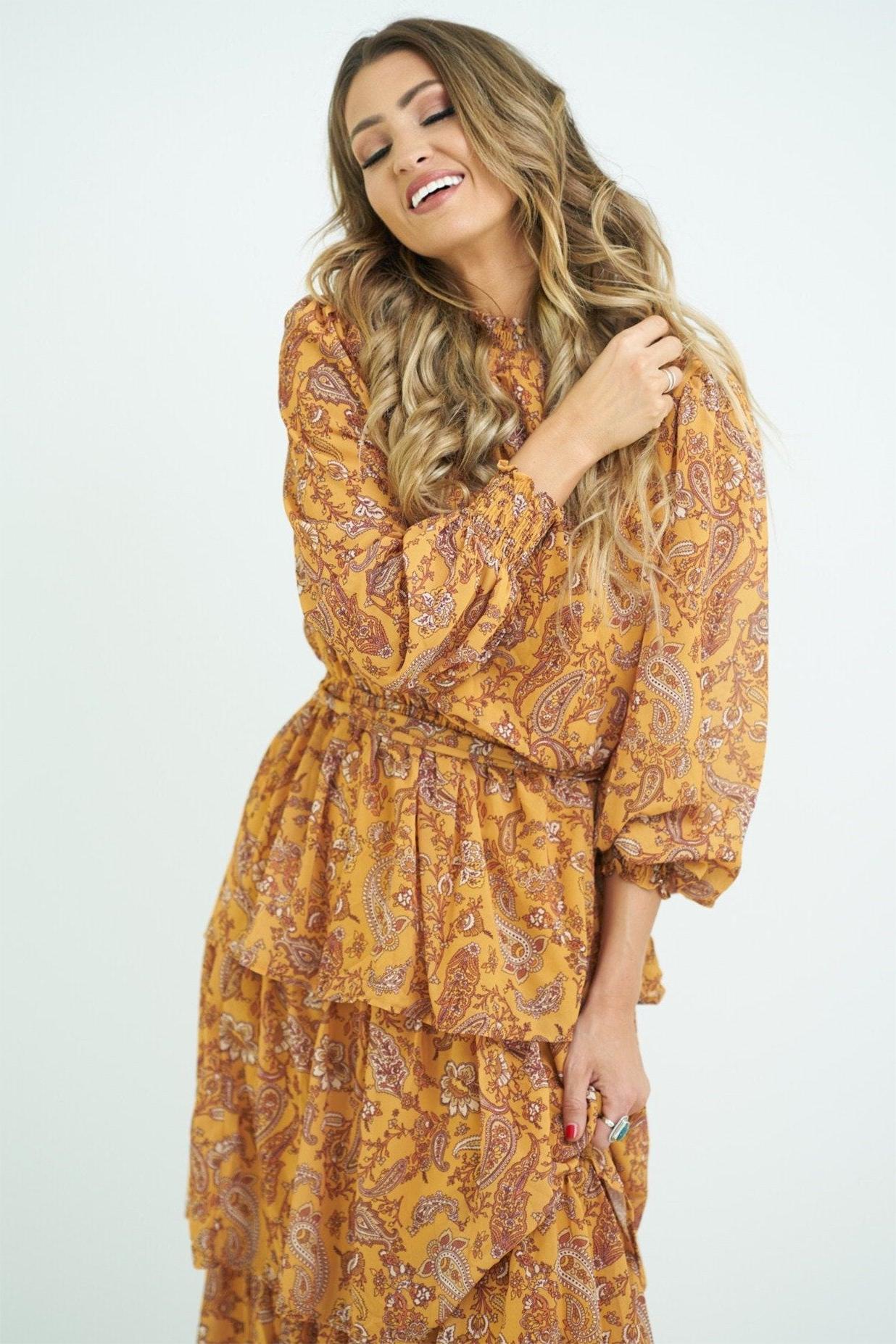Vestido largo con cuello alto, mangas farol y cinturón con volantes escalonados