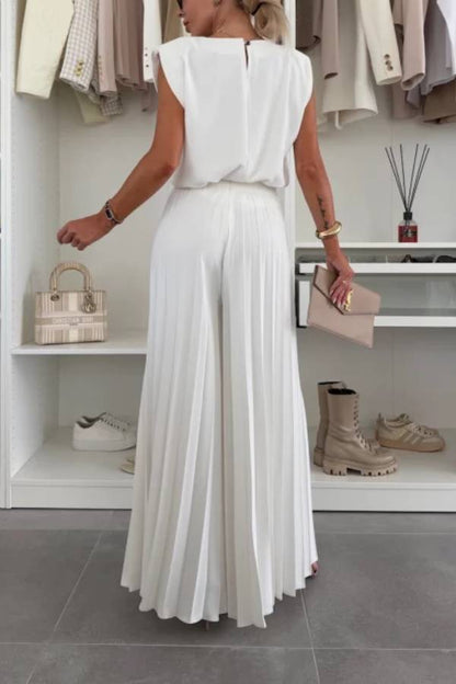 Conjunto de top de cuello redondo con hombreras y pantalones anchos plisados con cintura elástica.