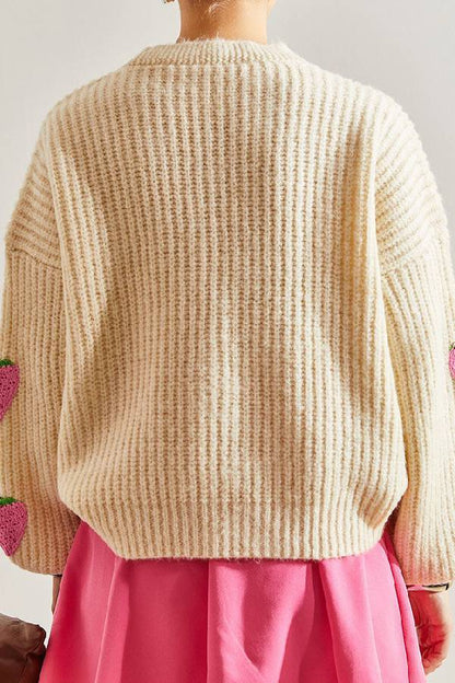 Suéter tipo cárdigan con cuello en V y decorado con fresas en color beige.