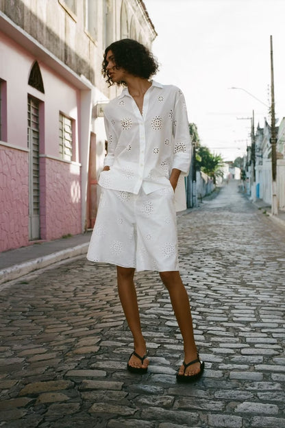 Traje informal blanco con escote en V, camisa bordada de media manga con aberturas y cintura alta, pantalones cortos informales con aberturas y aberturas.