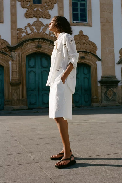 Traje informal blanco con escote en V, camisa bordada de media manga con aberturas y cintura alta, pantalones cortos informales con aberturas y aberturas.