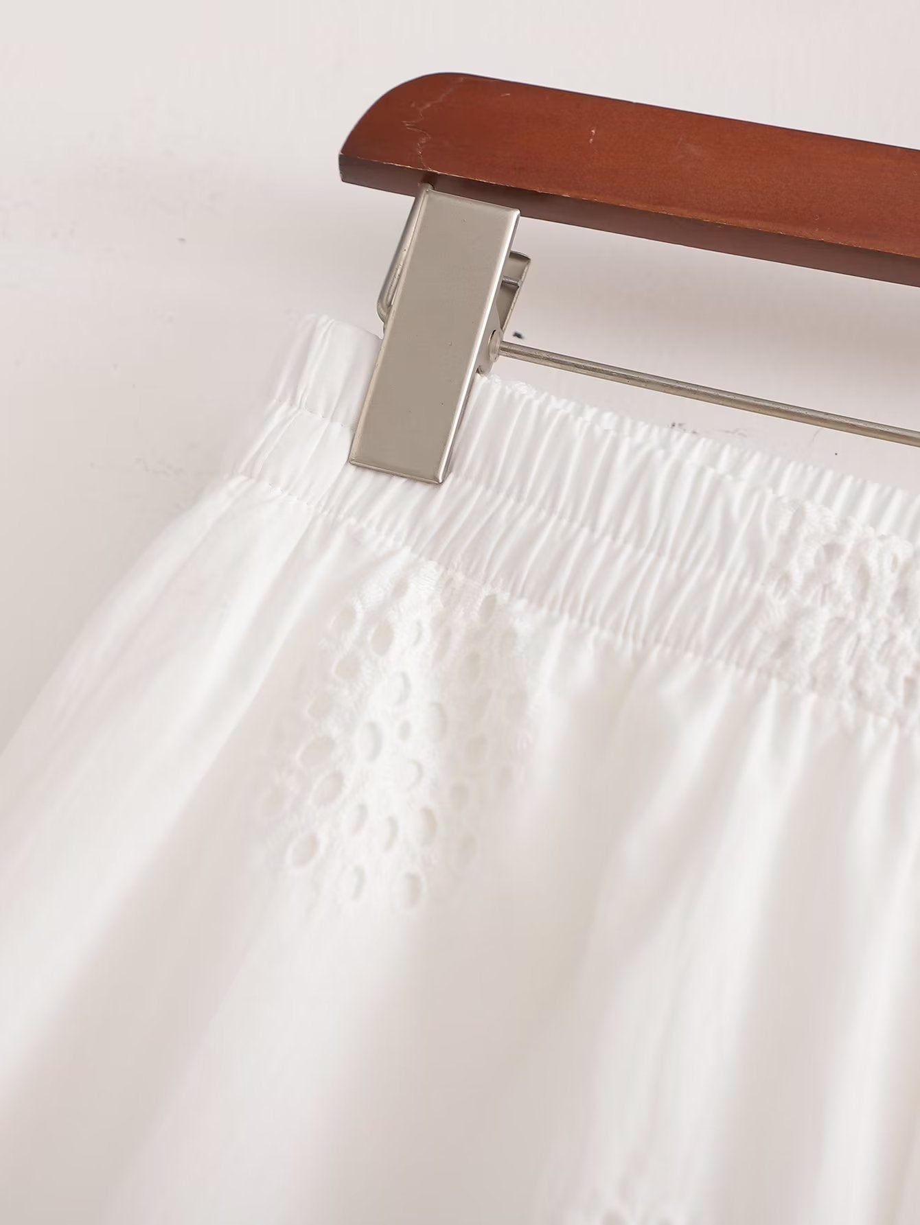 Traje informal blanco con escote en V, camisa bordada de media manga con aberturas y cintura alta, pantalones cortos informales con aberturas y aberturas.