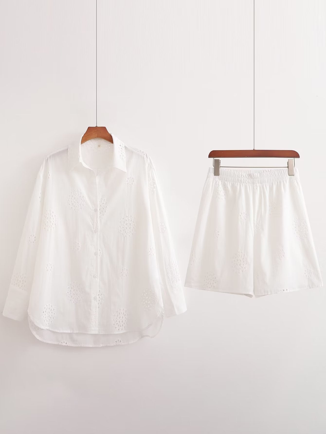 Traje informal blanco con escote en V, camisa bordada de media manga con aberturas y cintura alta, pantalones cortos informales con aberturas y aberturas.