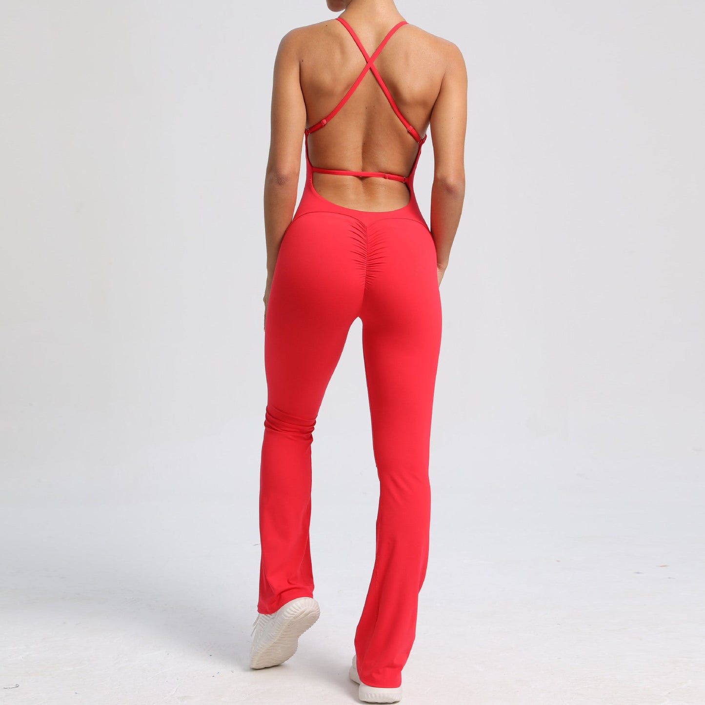 Mono de yoga de una pieza con tirantes ajustables y espalda descubierta, estilo deportivo, de color melocotón y cadera.