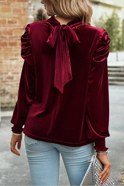 Blusa roja de terciopelo con cuello alto, mangas abullonadas y abertura en la boca