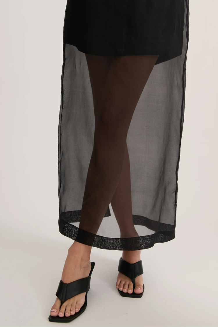 Conjunto moderno de camiseta extragrande con bolsillos de organza transparente y falda midi con abertura y tiro alto