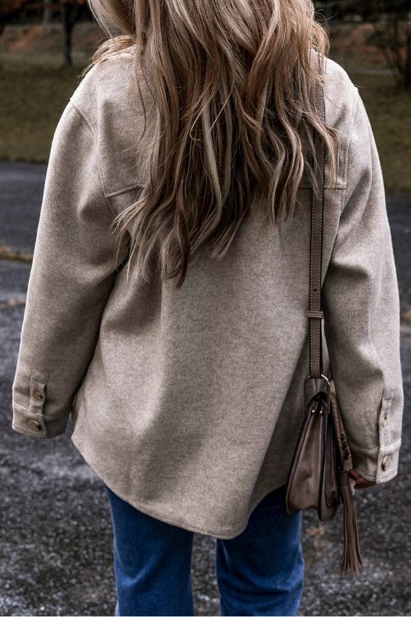 Chaqueta gris claro con cuello vuelto, bolsillos de solapa y botones