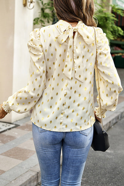 Elegante blusa de cuello alto con lunares y pliegues