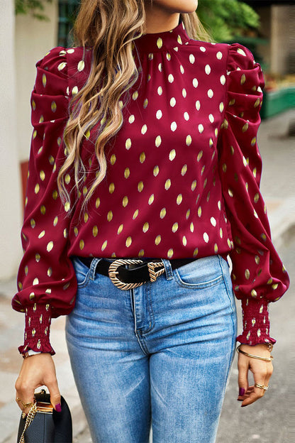 Elegante blusa de cuello alto con lunares y pliegues