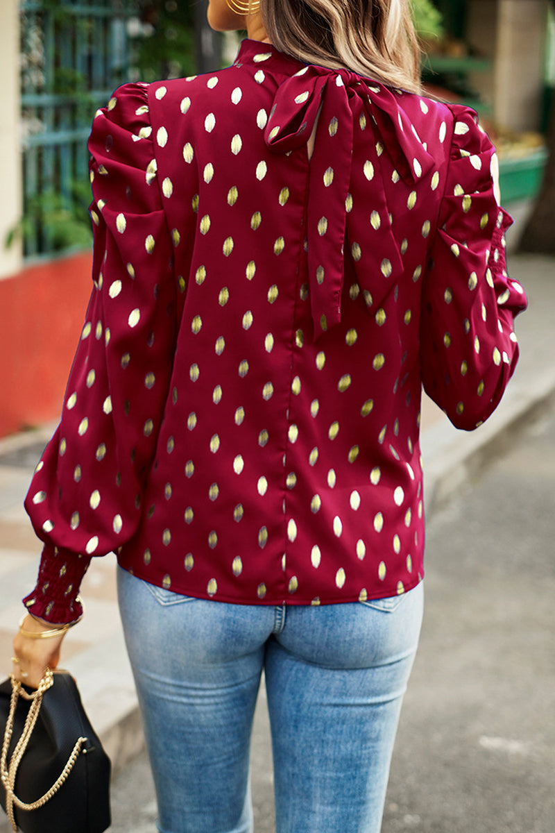 Elegante blusa de cuello alto con lunares y pliegues