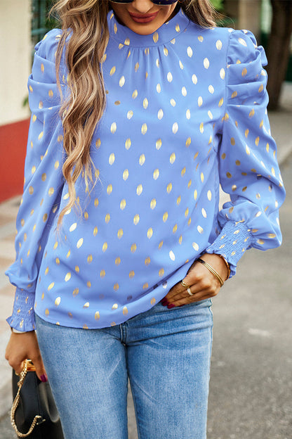 Elegante blusa de cuello alto con lunares y pliegues