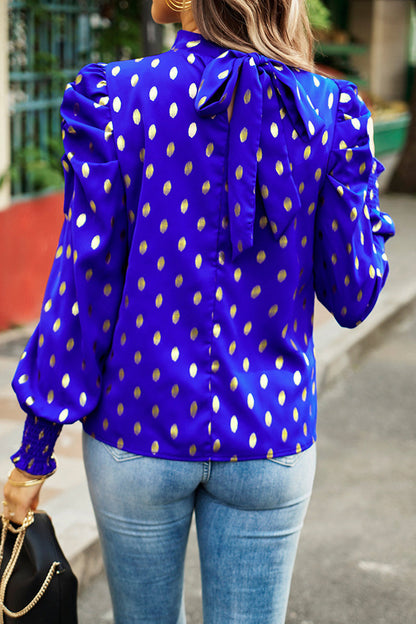 Elegante blusa de cuello alto con lunares y pliegues