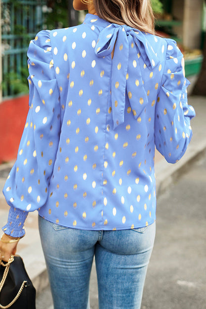 Elegante blusa de cuello alto con lunares y pliegues
