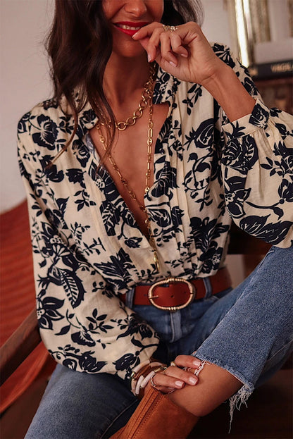 Camisa negra bohemia con estampado floral, cuello en V plisado y mangas farol 