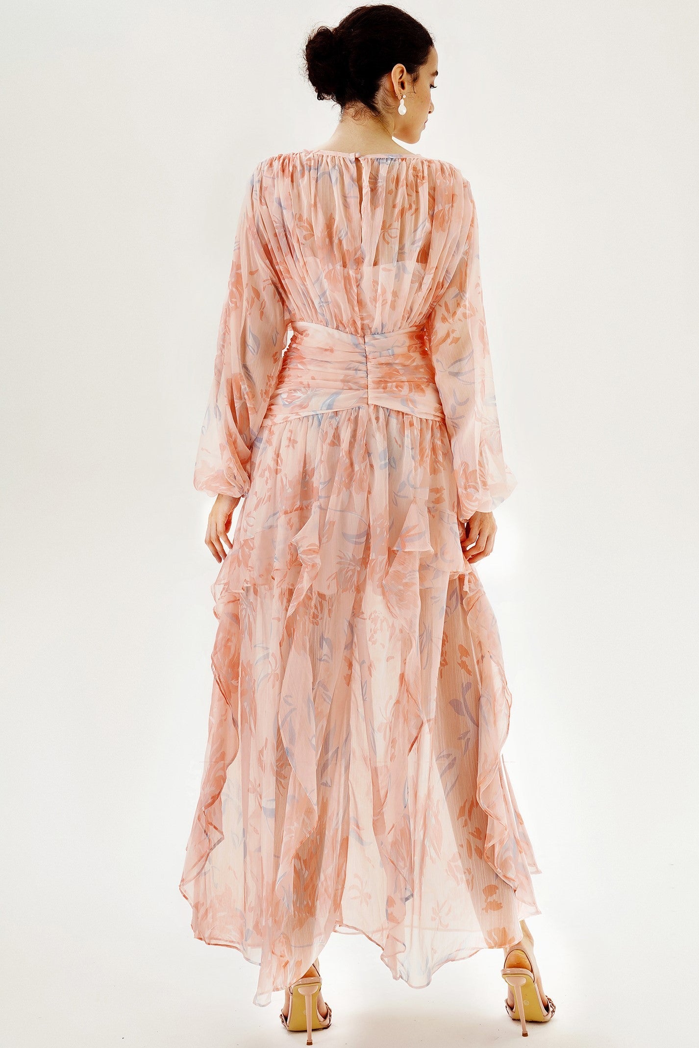 Vestido largo rosa con mangas largas abullonadas y bajo con volantes escalonados 