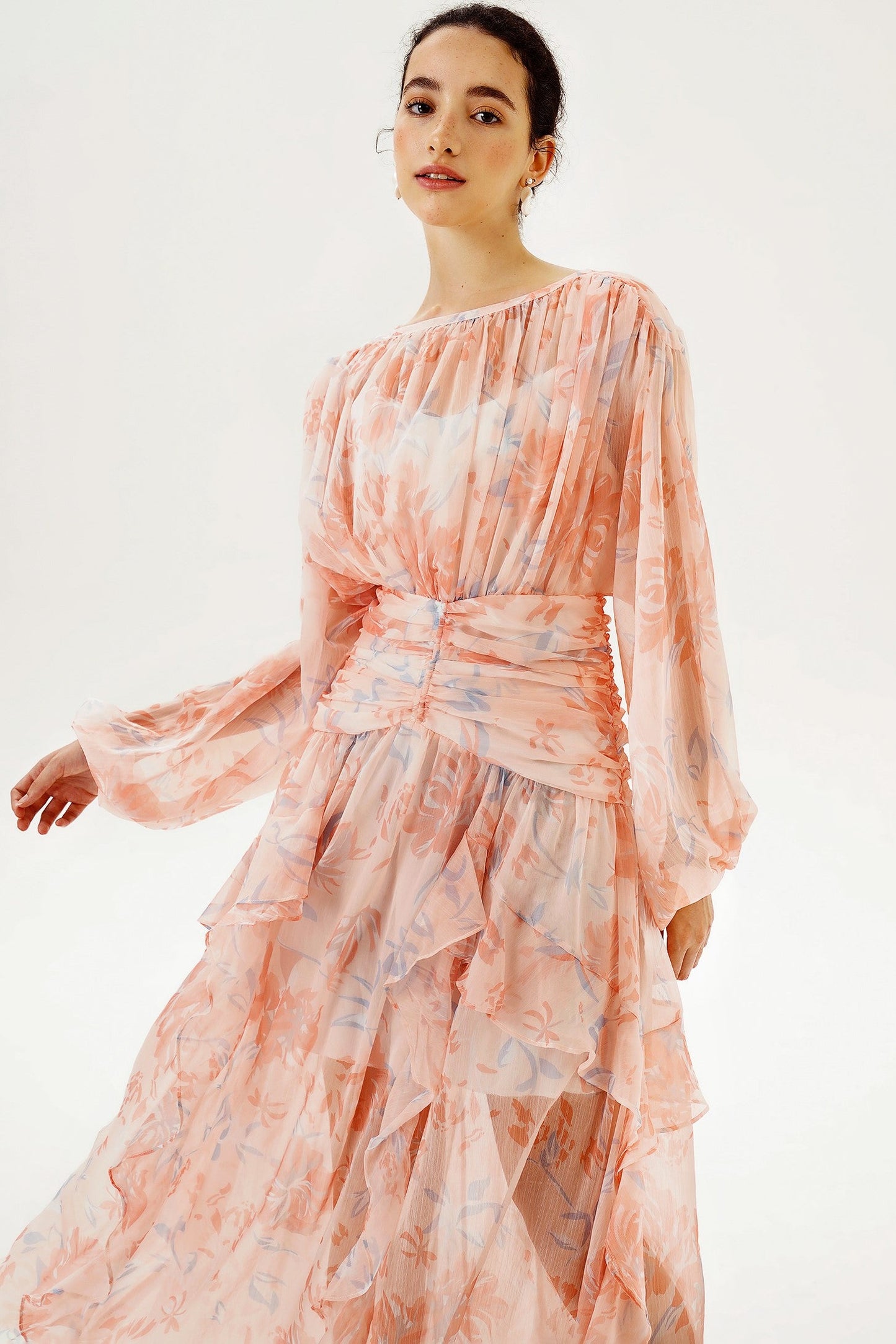 Vestido largo rosa con mangas largas abullonadas y bajo con volantes escalonados 