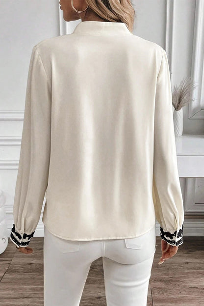 Camisa beige con botones y cuello alto con flores