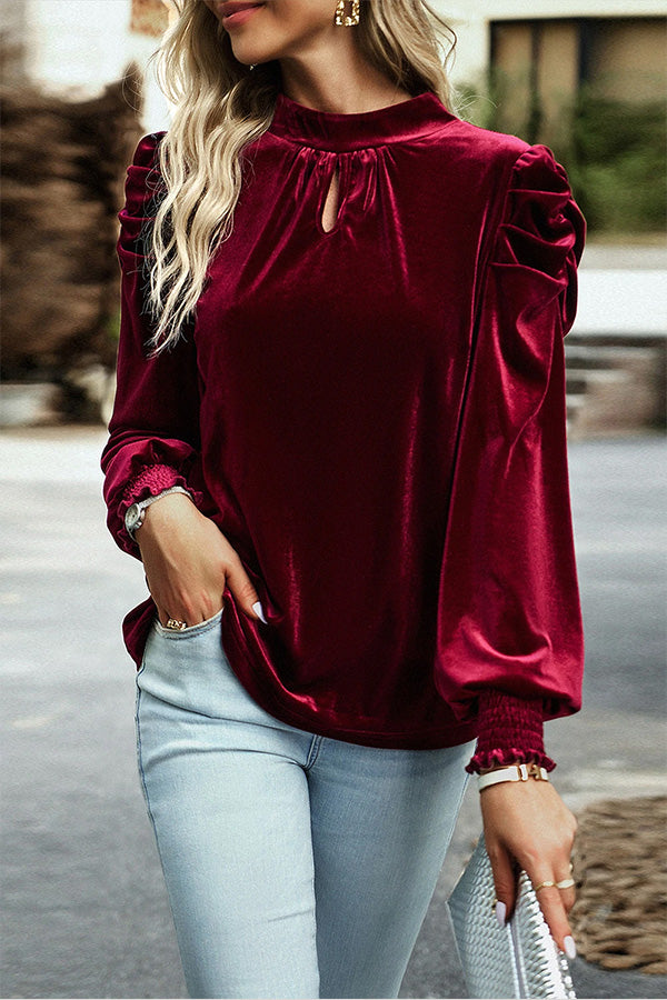 Blusa roja de terciopelo con cuello alto, mangas abullonadas y abertura en la boca