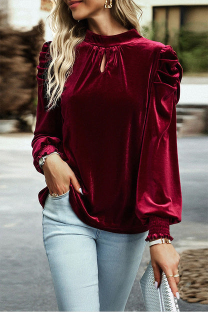 Blusa roja de terciopelo con cuello alto, mangas abullonadas y abertura en la boca