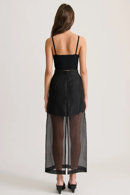 Conjunto moderno de camiseta extragrande con bolsillos de organza transparente y falda midi con abertura y tiro alto