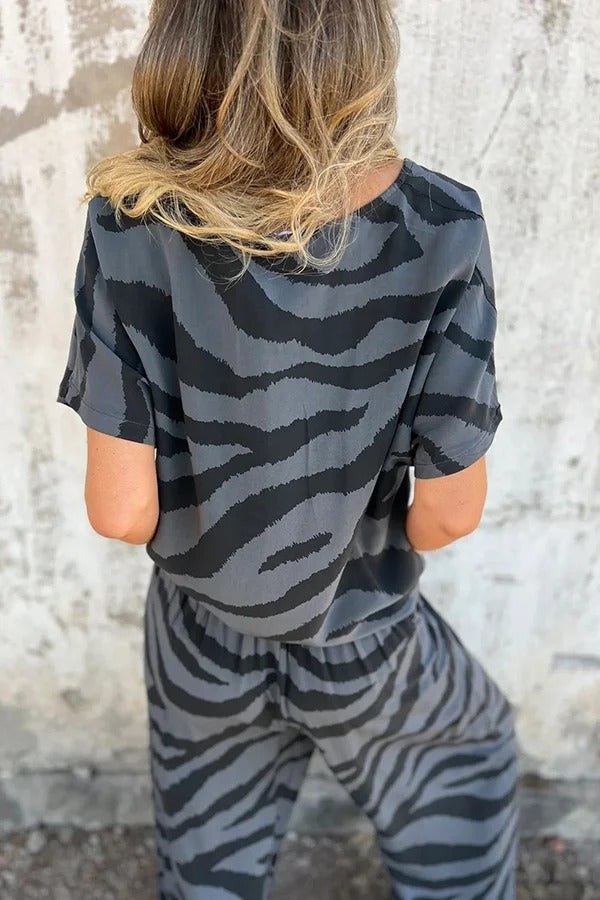 Conjunto de top con cuello en V, manga corta, cordones y pantalones rectos con cintura elástica y bolsillo. 