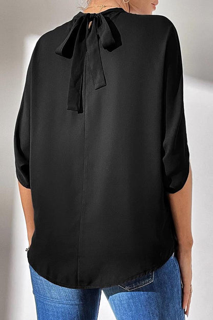 Top negro con cuello alto y mangas divididas