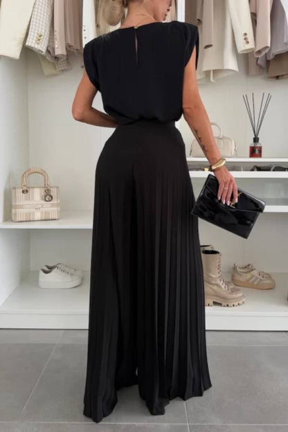 Conjunto de top de cuello redondo con hombreras y pantalones anchos plisados con cintura elástica.