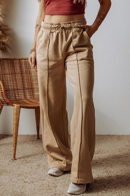 Pantalones anchos de cintura alta con cordón ajustable y costuras expuestas en gris humo