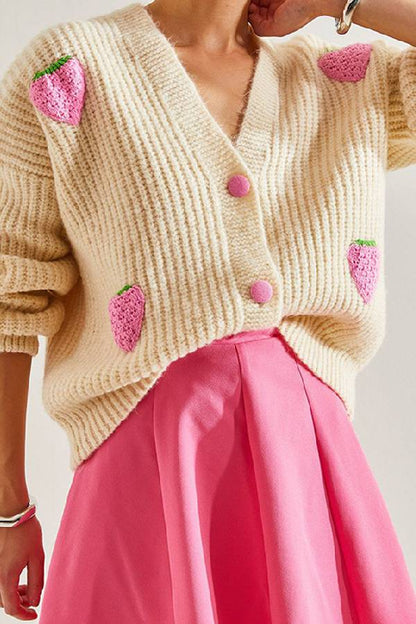 Suéter tipo cárdigan con cuello en V y decorado con fresas en color beige.