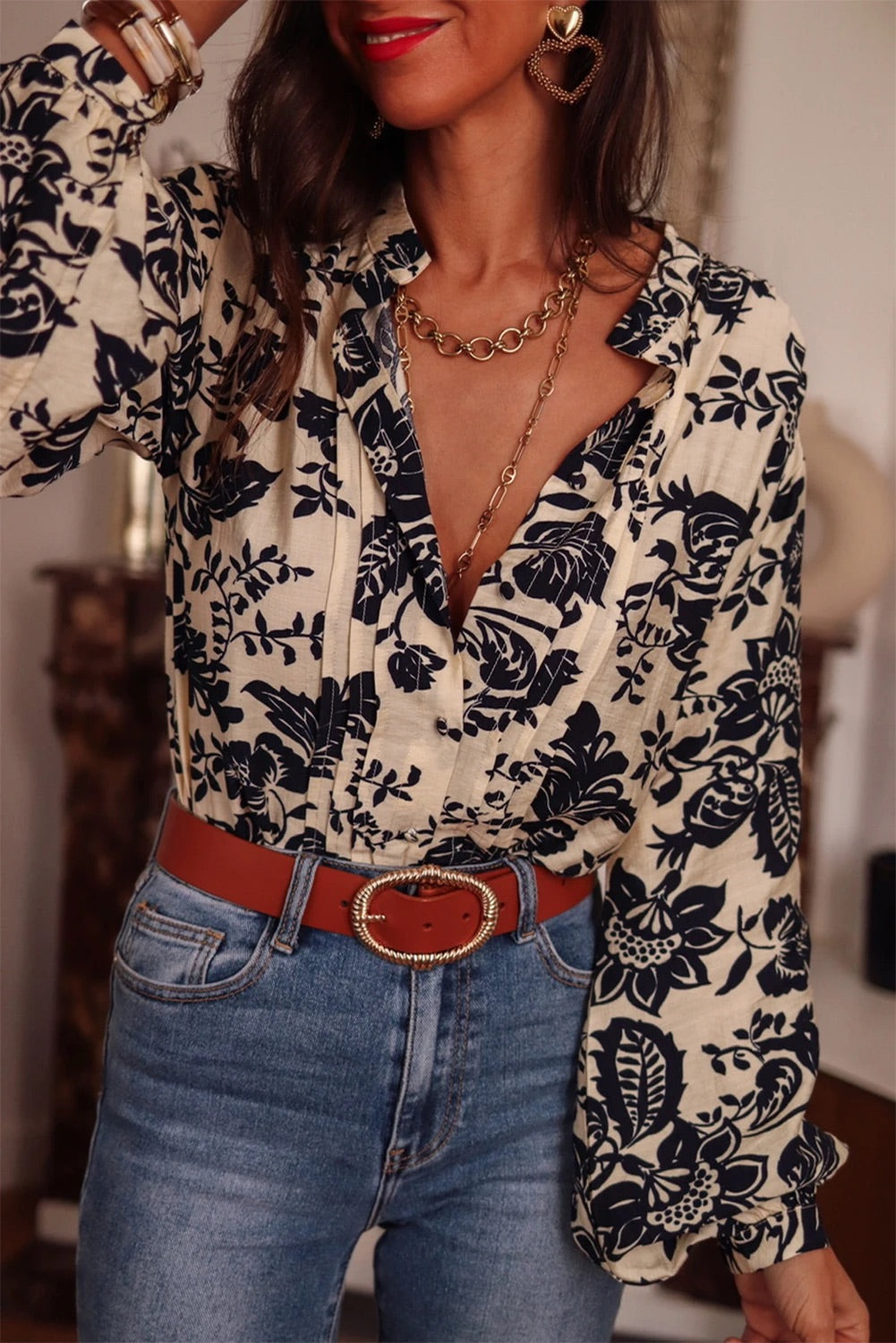 Camisa negra bohemia con estampado floral, cuello en V plisado y mangas farol 