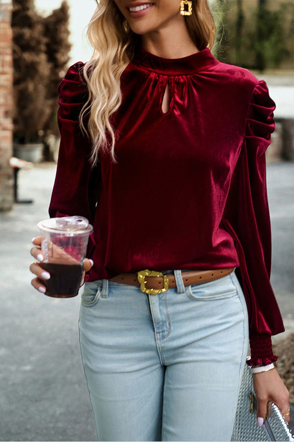 Blusa roja de terciopelo con cuello alto, mangas abullonadas y abertura en la boca
