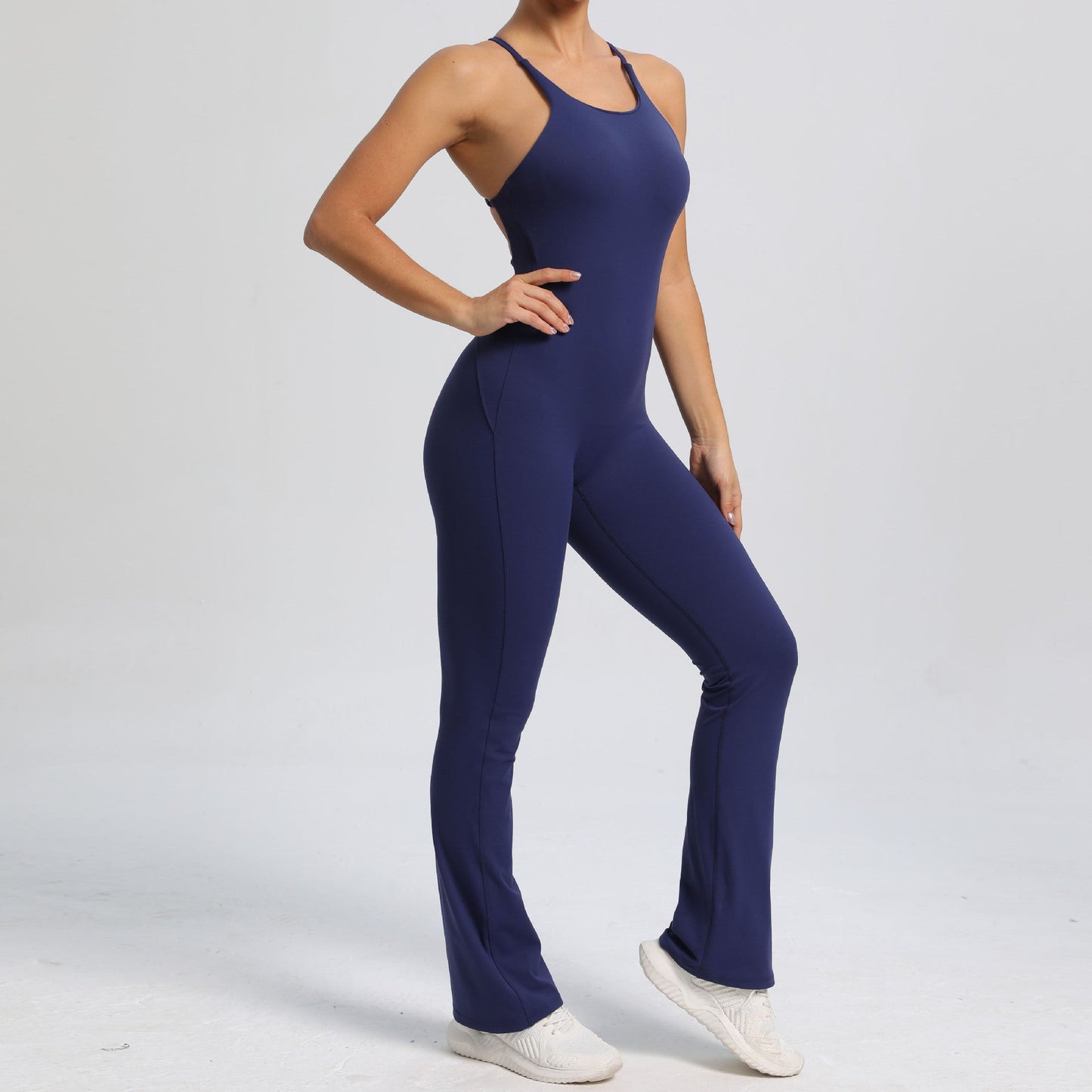 Mono de yoga de una pieza con tirantes ajustables y espalda descubierta, estilo deportivo, de color melocotón y cadera.