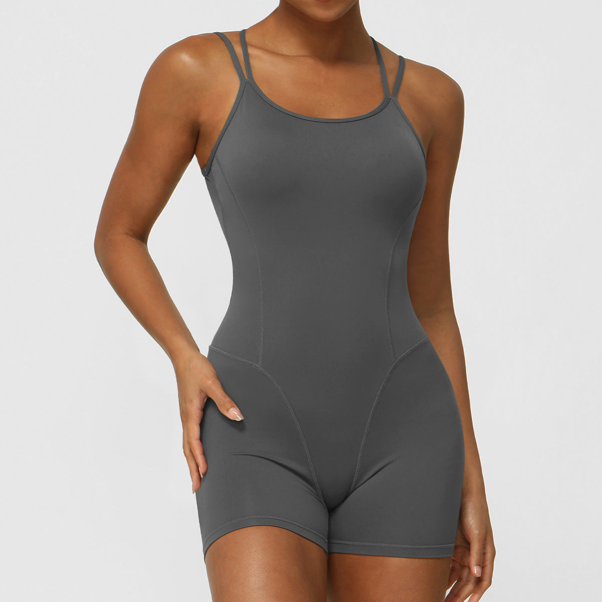 Mono deportivo de yoga con tirantes finos cruzados y espalda descubierta para mujer, con escote en V profundo y caderas pronunciadas.