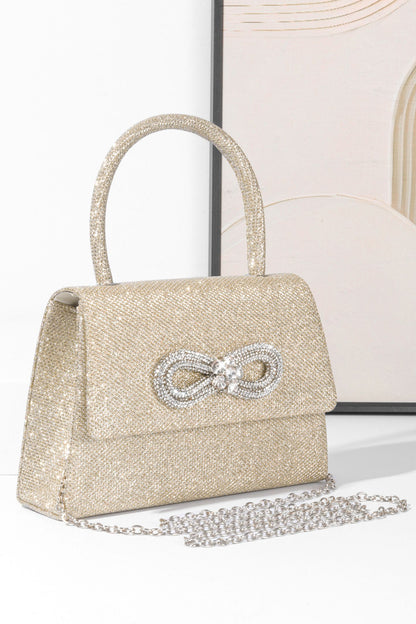 Bolso con asa de diamante y brillo metálico 