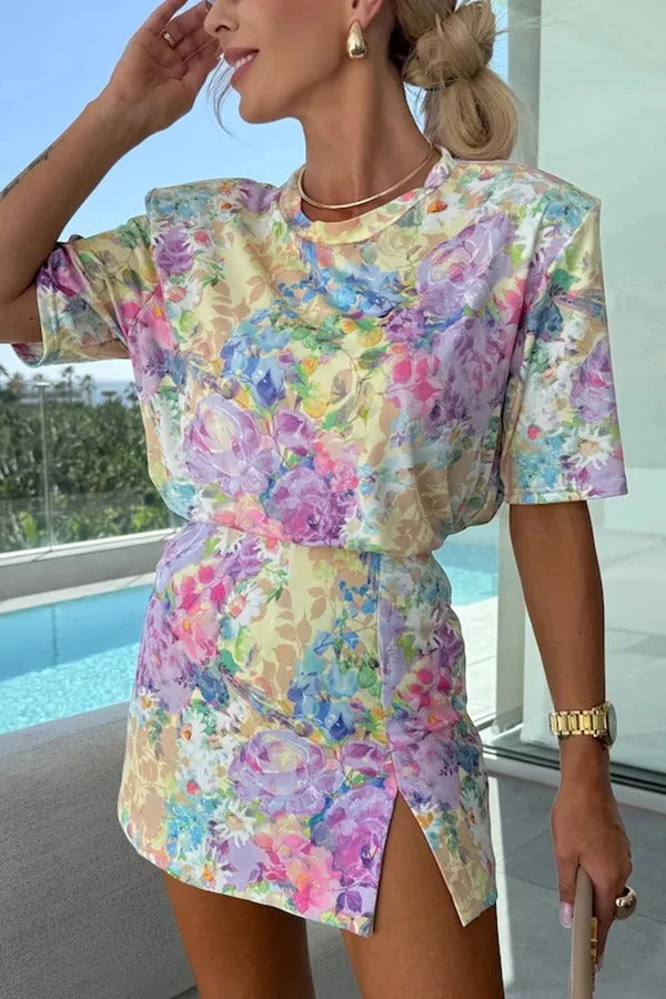 Hermoso conjunto de camiseta informal de manga corta con cuello redondo y estampado floral y falda pantalón con abertura de tiro medio