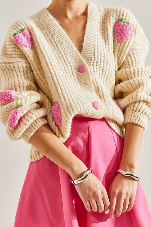 Suéter tipo cárdigan con cuello en V y decorado con fresas en color beige.