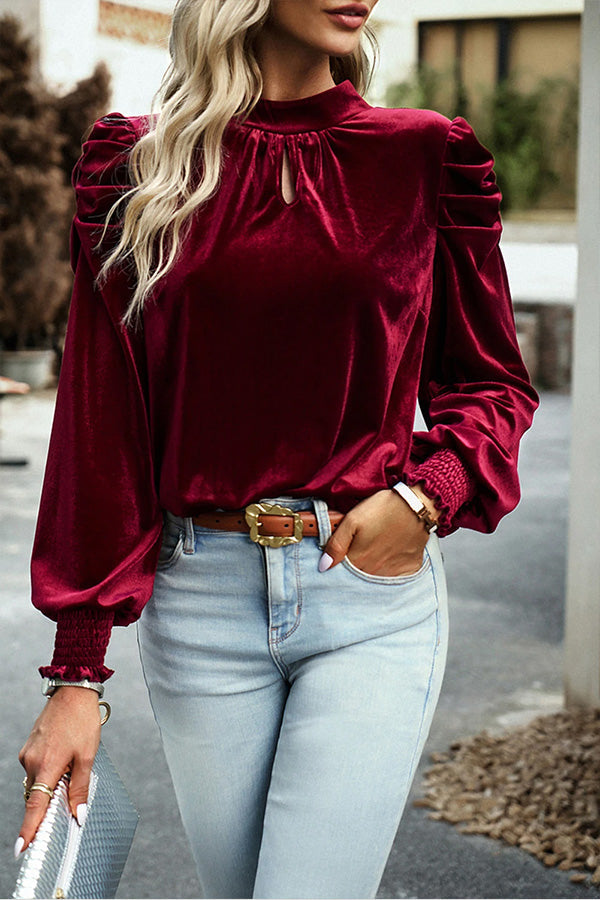 Blusa roja de terciopelo con cuello alto, mangas abullonadas y abertura en la boca