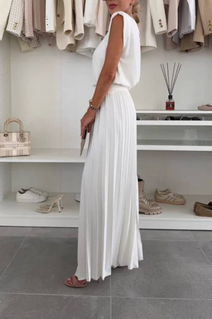 Conjunto de top de cuello redondo con hombreras y pantalones anchos plisados con cintura elástica.