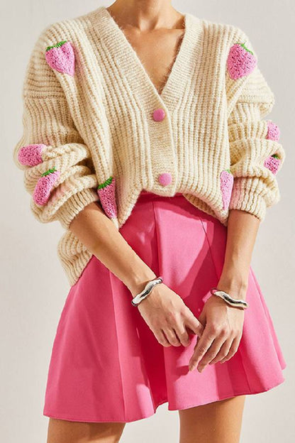 Suéter tipo cárdigan con cuello en V y decorado con fresas en color beige.