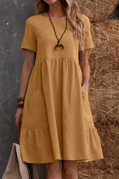 Vestido holgado de manga corta con cuello redondo y bolsillos en color liso