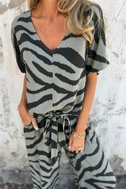 Conjunto de top con cuello en V, manga corta, cordones y pantalones rectos con cintura elástica y bolsillo. 
