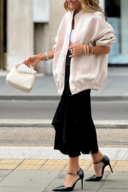 Abrigo de mujer de color liso con cuello alto y bolsillos grandes.