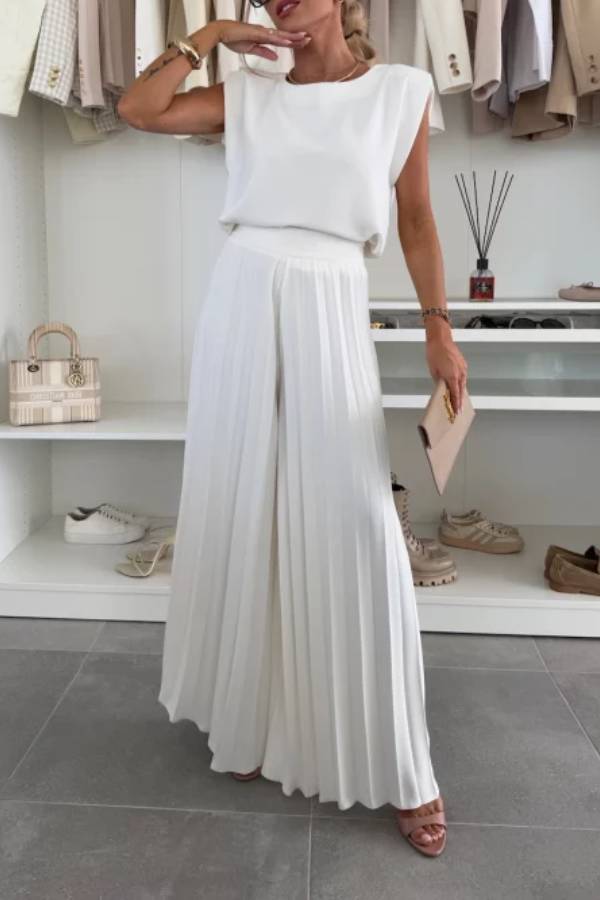 Conjunto de top de cuello redondo con hombreras y pantalones anchos plisados con cintura elástica.
