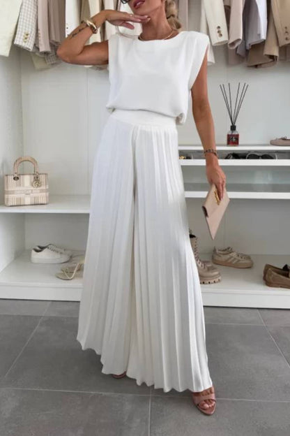 Conjunto de top de cuello redondo con hombreras y pantalones anchos plisados con cintura elástica.